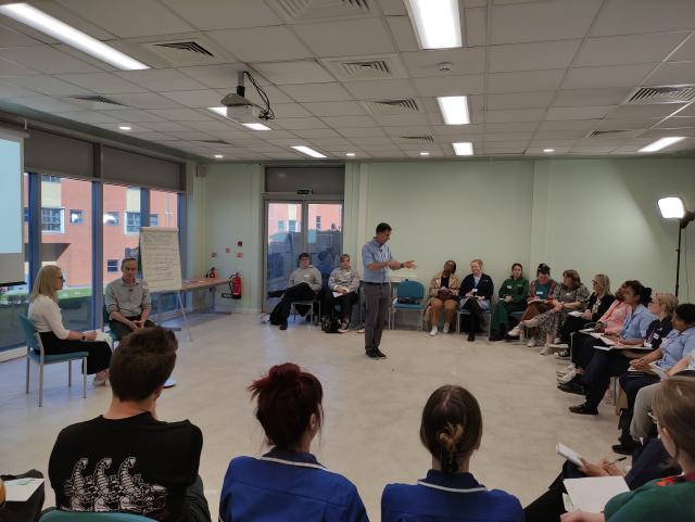 People sitting in a large circle in a workshop